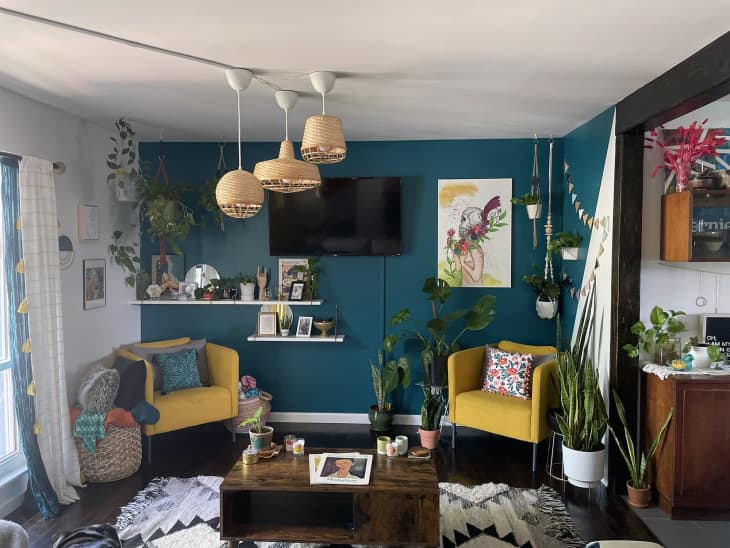 Teal and white living room with yellow armchairs and rattan pendant lights